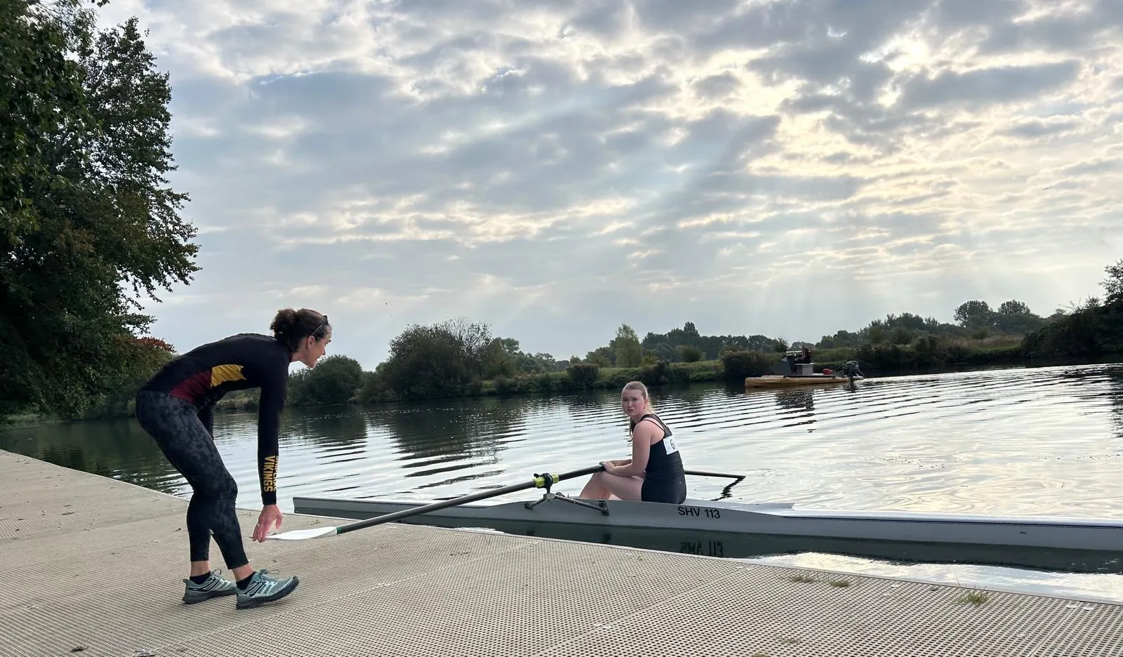 A Shiplake Vikings coach pushing off a single scull carrying a competitor at the start of the 1000m rowing leg